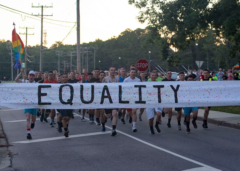 Event participants run to break through a banner during a Pride Observance Month 5K run at Joint Base Langley-Eustis, Virginia, June 21, 2019.