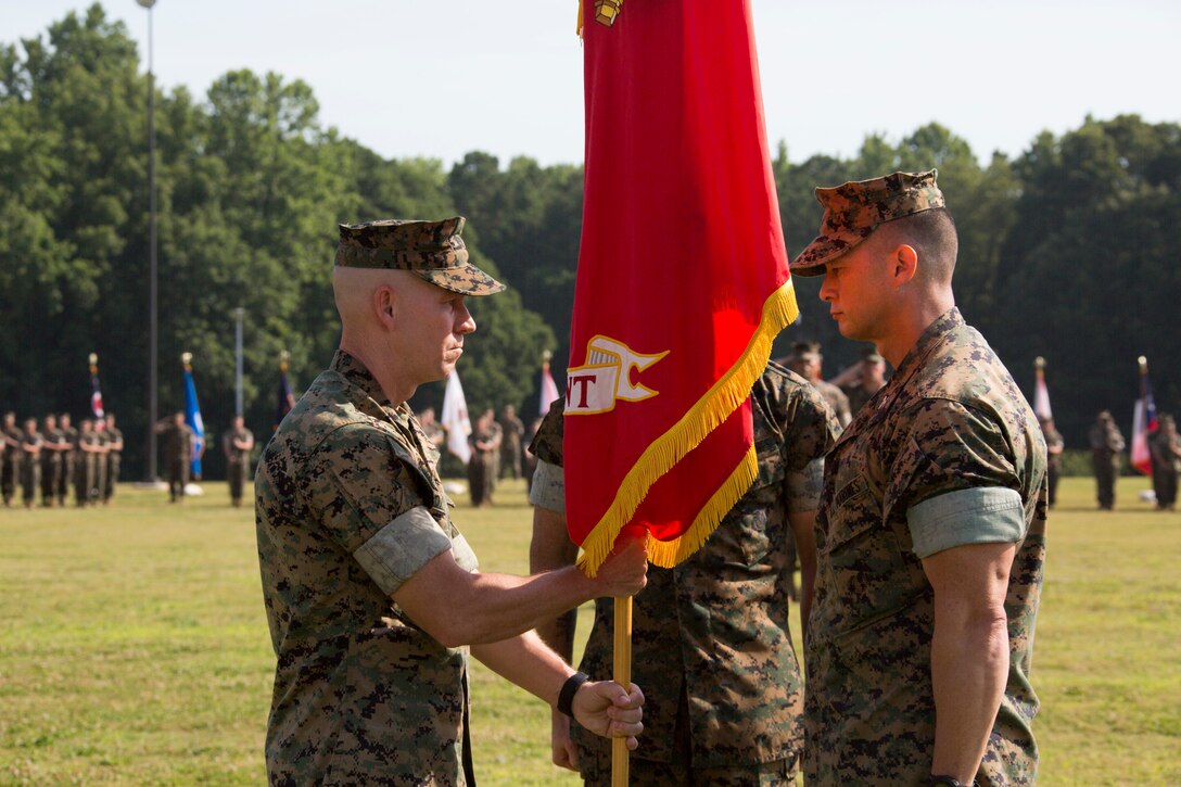 U.S. Marine Corps Col. Corey M. Collier, left, the incoming commanding officer of Marine Corps Security Force Regiment, U.S. Marine Corps Forces Command, takes the regiments colors from Col. Brain W. Neil, the outgoing regiment commanding officer, during a change of command ceremony at Naval Weapons Station Yorktown, Yorktown, Virginia, June 28, 2019. The change of command is a time-honored tradition where the responsibilities and authority of command are ceremoniously passed from one commander to the next. (U.S. Marine Corps photo by Sgt. Jessika Braden/ Released)