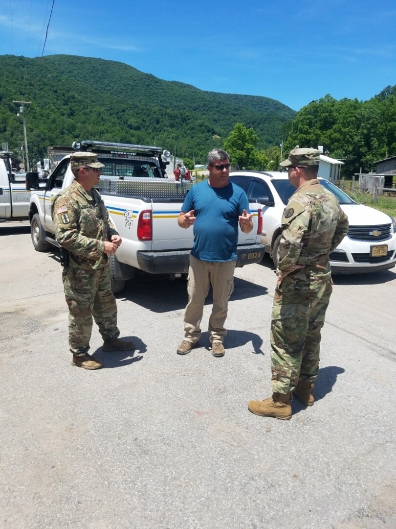 U.S. Army Capt. Steven Frey and Chief Warrant Officer 2 David Marple talk with a representative of the West Virginia Division of Highways July 1, 2019, in Randolph County, West Virginia. Frey and Marple are a liaison officer team from the West Virginia National Guard who are assisting the Randolph County Emergency Operations Center with coordinating response and recovery from flooding on June 30, 2019.