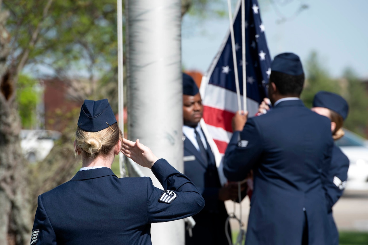Airman saluting flag.