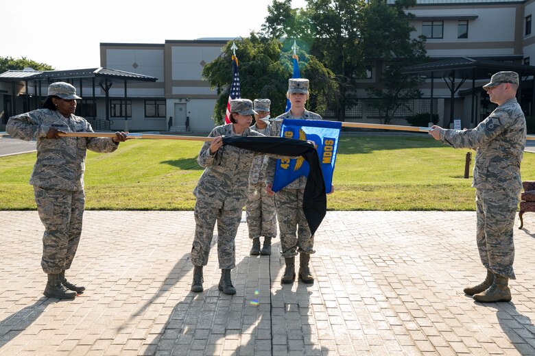 Col. Patricia Fowler, 436th Medical Group commander, removes the case from the newly designated 436th Health Care Operations Squadron guidon as Lt. Col. Lisa Palmer, 436th Medical Operations Squadron commander, prepares to furl the guidon of the 436th MDOS during a redesignation ceremony June 28, 2019, at the 436th MDG on Dover Air Force Base, Del. The 436th MDOS was re-designated as the 436th HCOS, whose focus is to provide care to all non-active duty beneficiaries. (U.S. Air Force photo by Roland Balik)