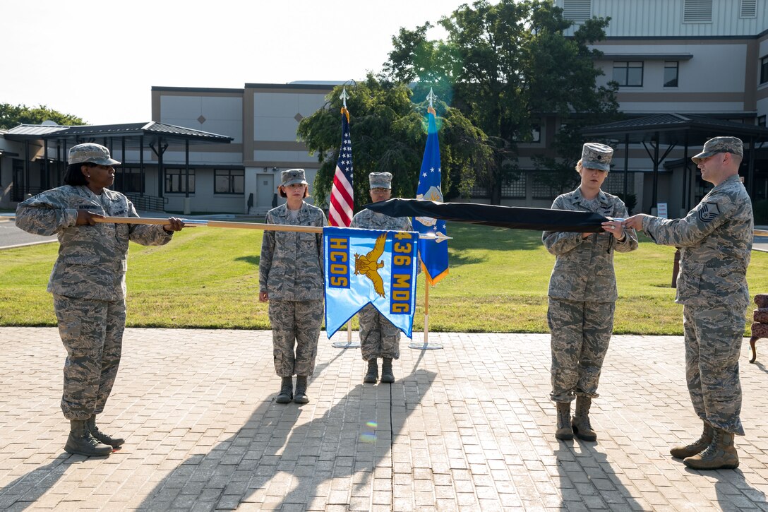 Col. Patricia Fowler, 436th Medical Group commander, watches Lt. Col. Lisa Palmer, 436th Medical Operations Squadron commander encase the 436th MDOS guidon held by Master Sgt. Chad Boley, 436th MDOS superintendent, during a redesignation ceremony June 28, 2019, at the 436th MDG on Dover Air Force Base, Del. Chief Master Sgt. Erica Hammond, 436th MDG superintendent, unfurled the guidon of the newly designated 436th Health Care Operations Squadron. (U.S. Air Force photo by Roland Balik)