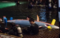CTC Engineers divers from the Frederick County Career and Technology Center (FCCTC) in Maryland sit with their submarine, CLS Mako, as they await their final run in the David Taylor Model Basin at the 15th International Submarine Races on June 28 at Naval Surface Warfare Center, Carderock Division (NSWCCD) in West Bethesda, Md.