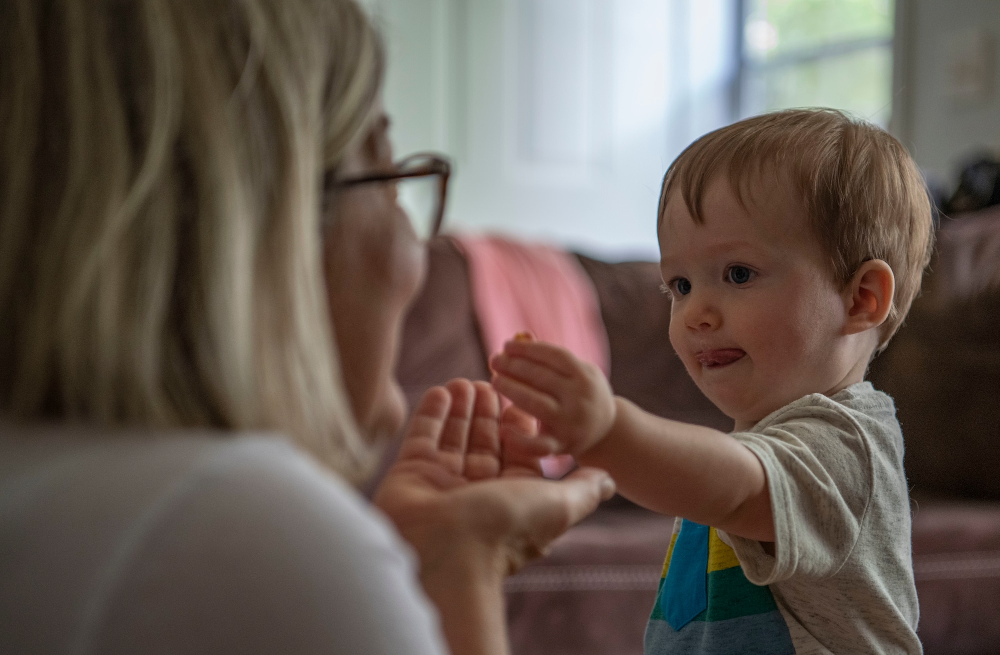 Child hands food to family advocacy program nurse