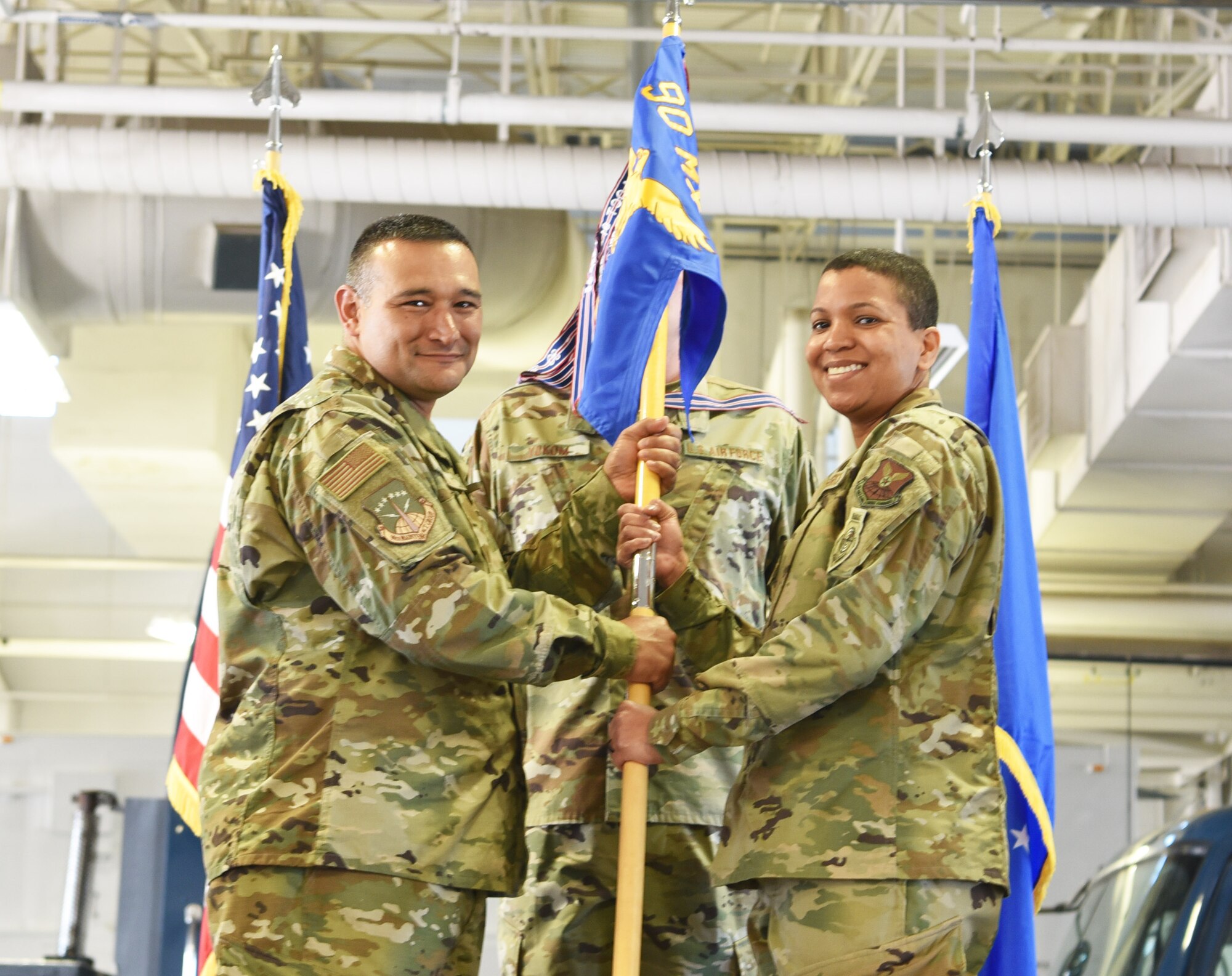 Colonel Brian Rico, 90th Maintenance Group commander, passes the guidon to Maj. Christine Hernandez, 90th Missile Maintenance Squadron incoming commander, during the 90th MMXS change of command ceremony June 28, 2019, on F.E. Warren Air Force Base, Wyo. The ceremony signified the transition of command from Lt. Col. Stephanie Wilson to Hernandez. (U.S. Air Force photo by 2nd Lt. Emily Seaton)