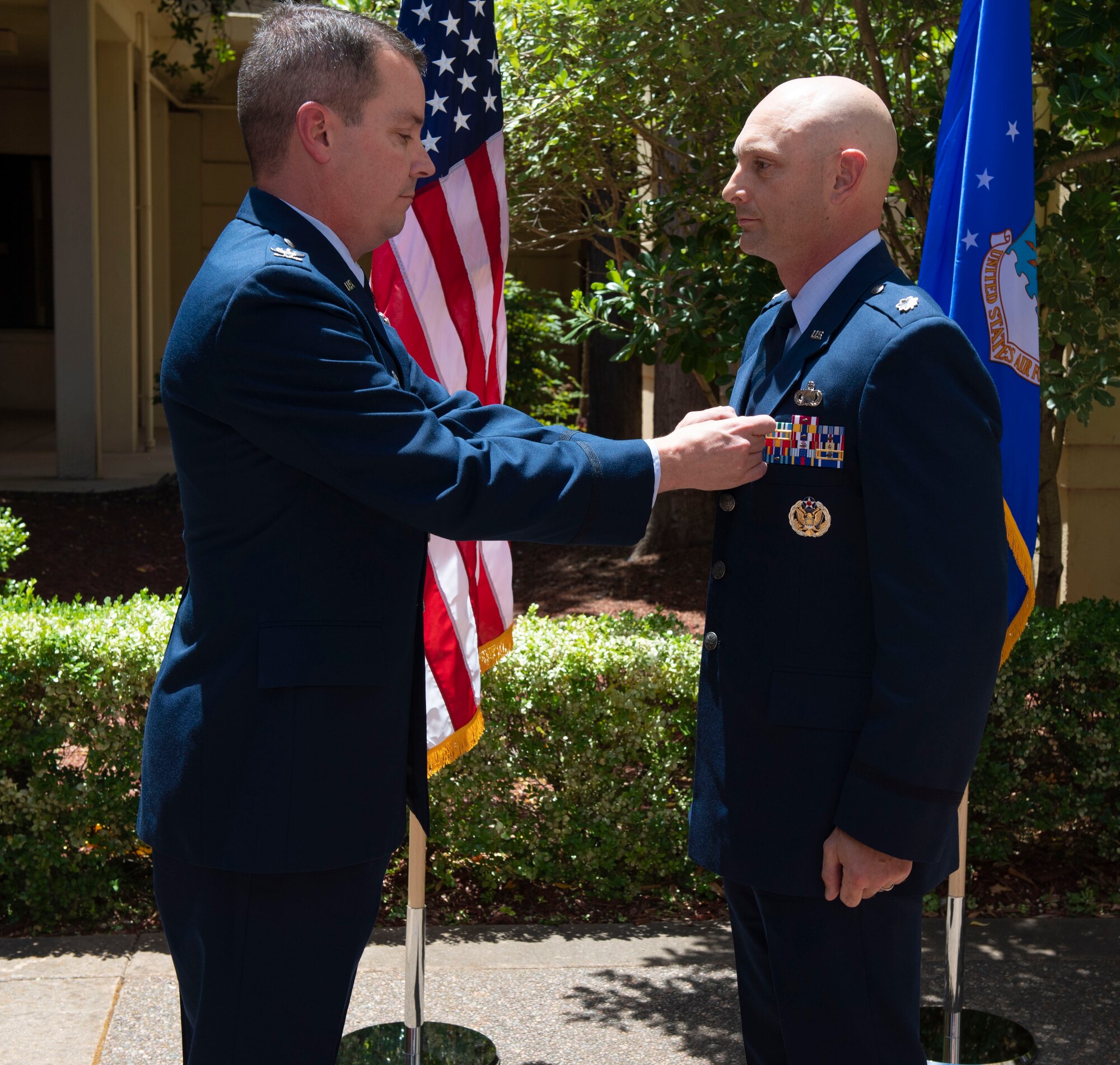 U.S. Air Force Col. Jeff Nelson, left, 60th Air Mobility Wing commander, pins a meritorious service medal on Lt. Col. Jared Mitchell, outgoing 60th Comptroller Squadron commander, June 28, 2019, at Travis Air Force Base, California. During the ceremony, Mitchell passed the reign of command to Maj. Andrew Wilkins. (U.S. Air Force photo by Airman 1st Class Jonathon Carnell)