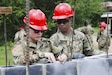 Cadet Jenna Yorko, 365th Engineer Battalion, Schuylkill Haven, Pa., takes notes with Spc. Germain Brown at Eucalypto school construction site during exercise Beyond the Horizon.