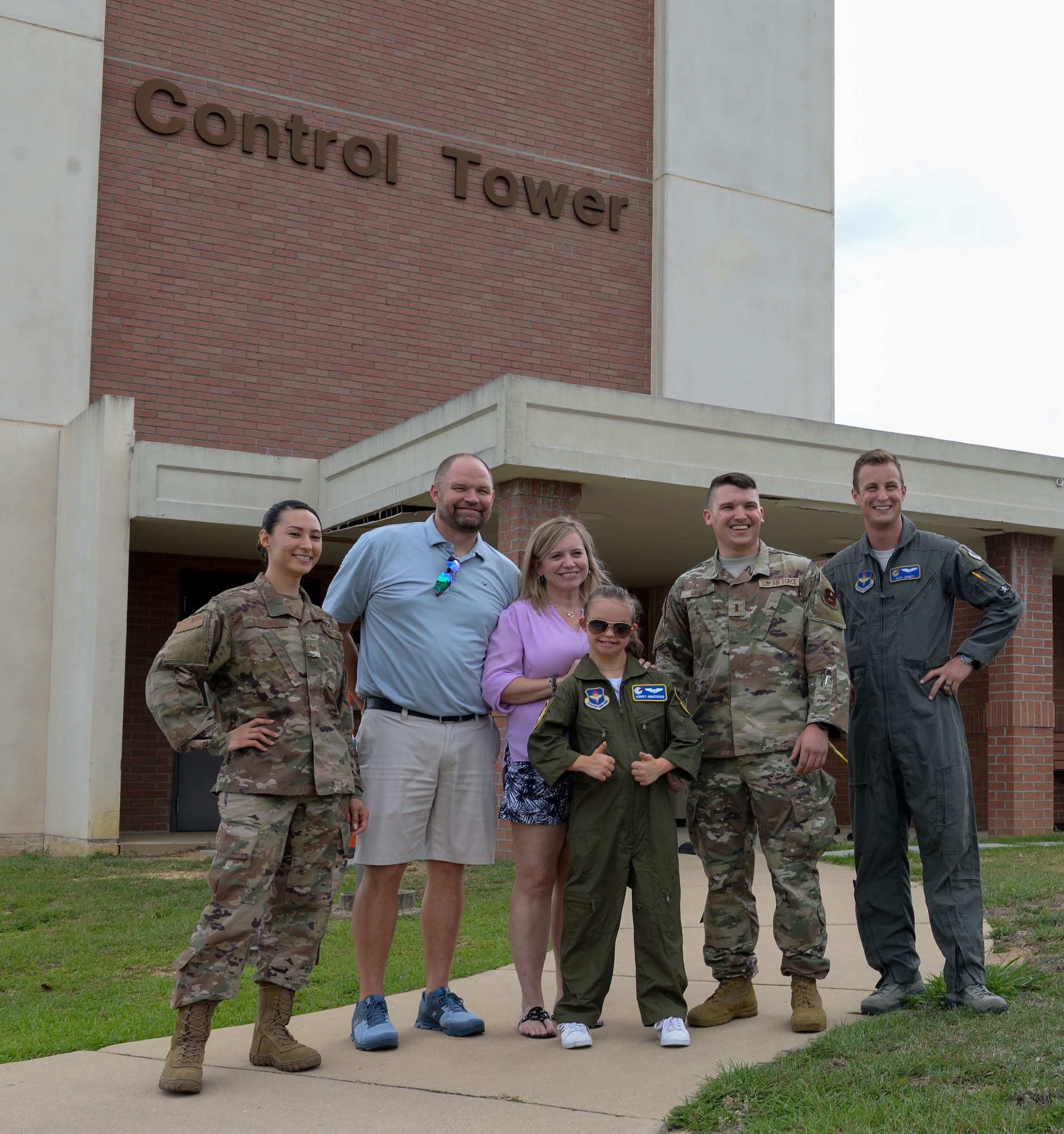 Aubrey Armstrong, her parents, an instructor pilot and members of the 14th Operations Group, stand in front of the Control Tower June 25, 2019, on Columbus Air Force Base, Miss. Aubrey went to the top of the Control Tower and caught a view of aircraft taking off. (U.S. Air Force photo by Airman Davis Donaldson)