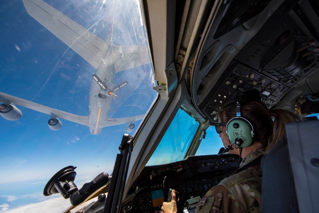 A airman flies a plane from with another plane in the distance.