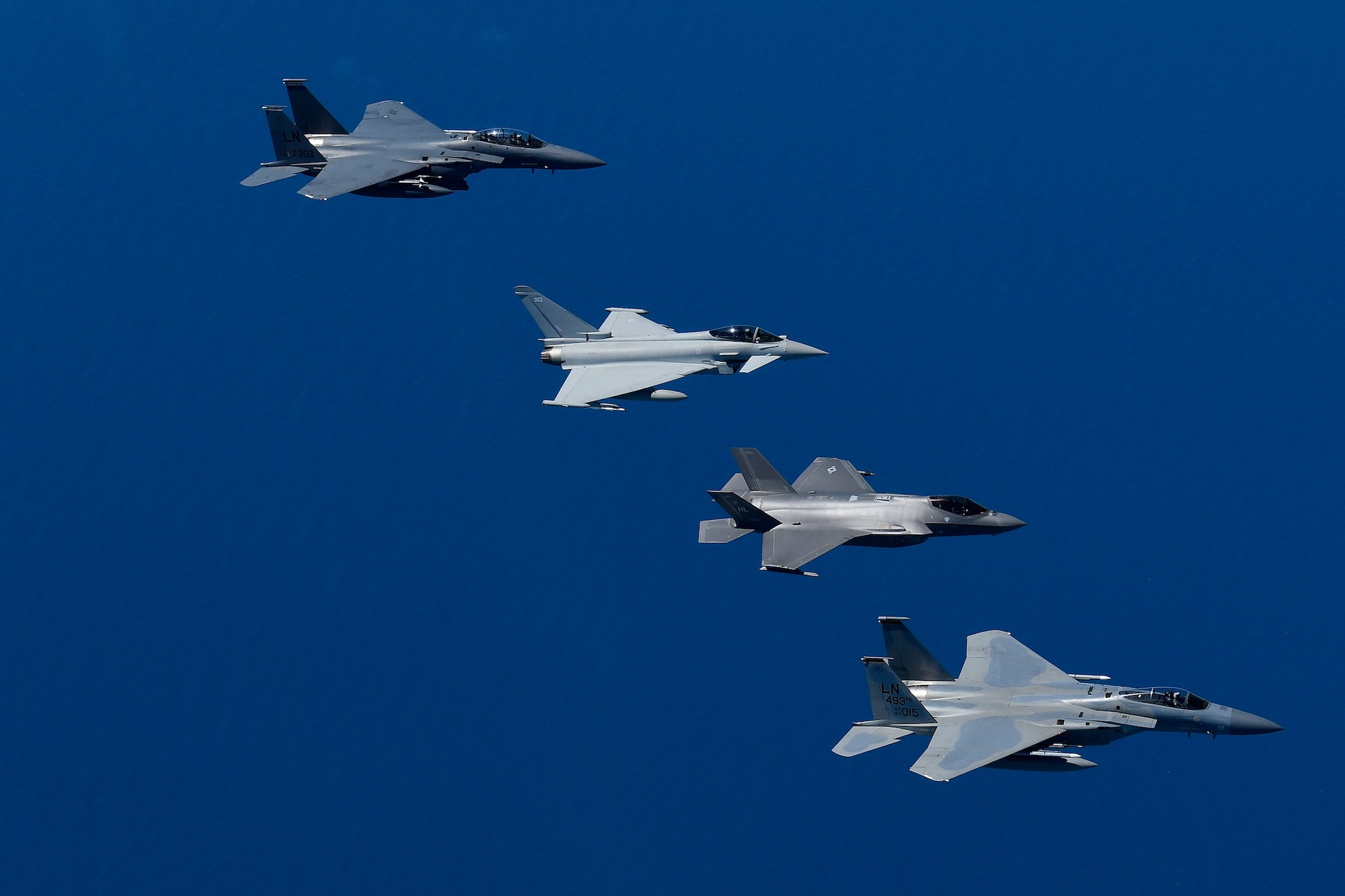 U.S. Air Force fourth and fifth-generation aircraft fly in an echelon formation with a Royal Air Force Typhoon in support of exercise Pointblank 19-2, over the North Sea, June 27, 2019. The objective of the exercise is to prepare coalition warfighters for a highly contested fight against near-peer adversaries by providing a multi-dimensional battle-space to conduct advanced training in support of US, UK and French national interests. (U.S. Air Force photo/ Tech. Sgt. Matthew Plew)