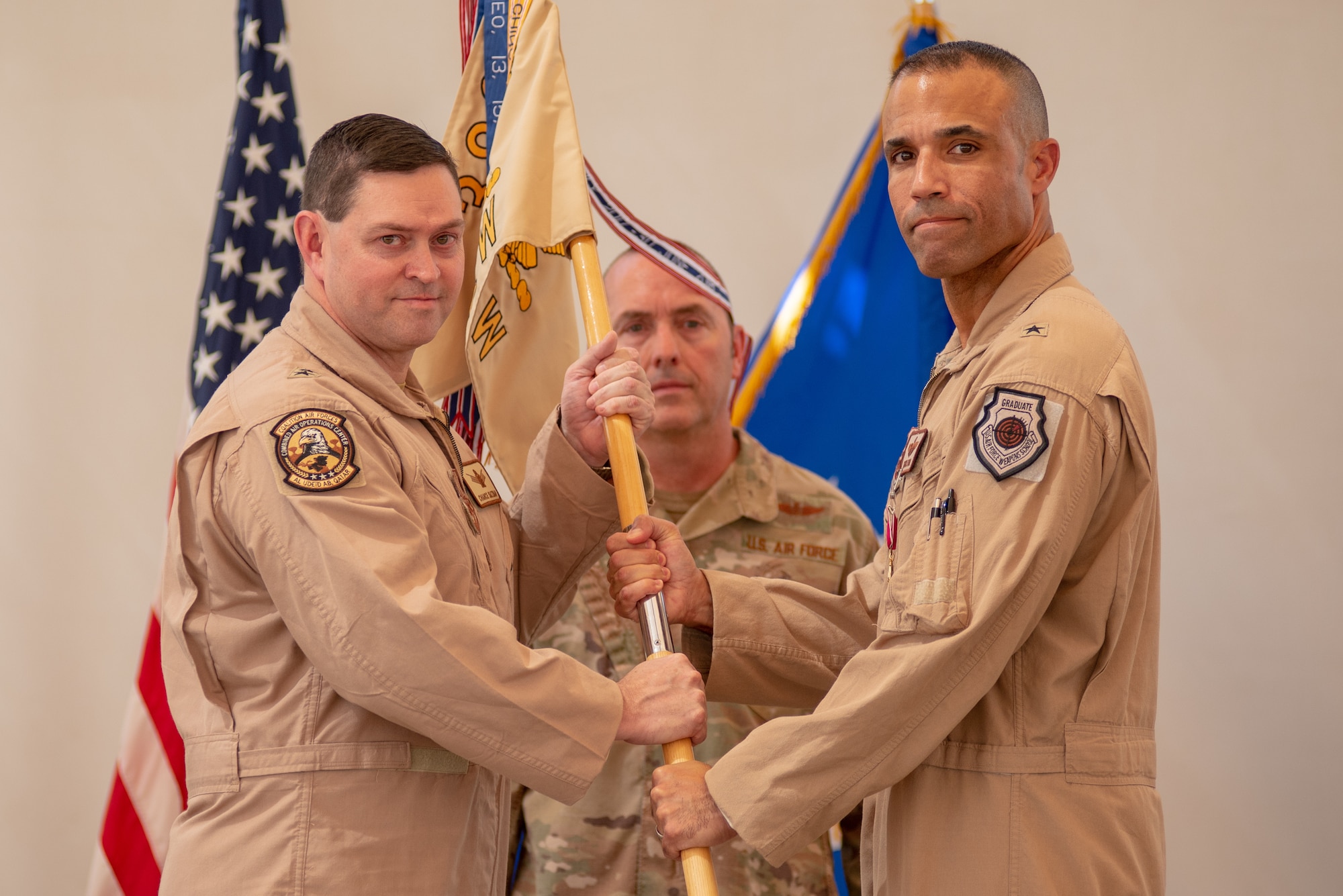 Brig. Gen. Adrian L. Spain, right, 380th Air Expeditionary Wing commander, relinquishes command during the wing change of command ceremony July 1, 2019, at Al Dhafra Air Base, United Arab Emirates.