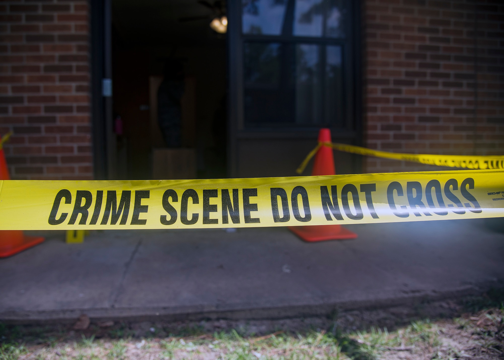 Crime-scene tape blocks off the entrance to a simulated crime scene, June 26, 2019, at Moody Air Force Base, Ga. Investigators from the 23d Security Forces Squadron are required to respond to incidents and scenarios that require a high level of attention and sensitivity. Investigators are responsible for the collection, preservation and transportation of evidence from a crime scene, along with suspect detainment and interrogation. (U.S. Air Force photo by Airman 1st Class Eugene Oliver)