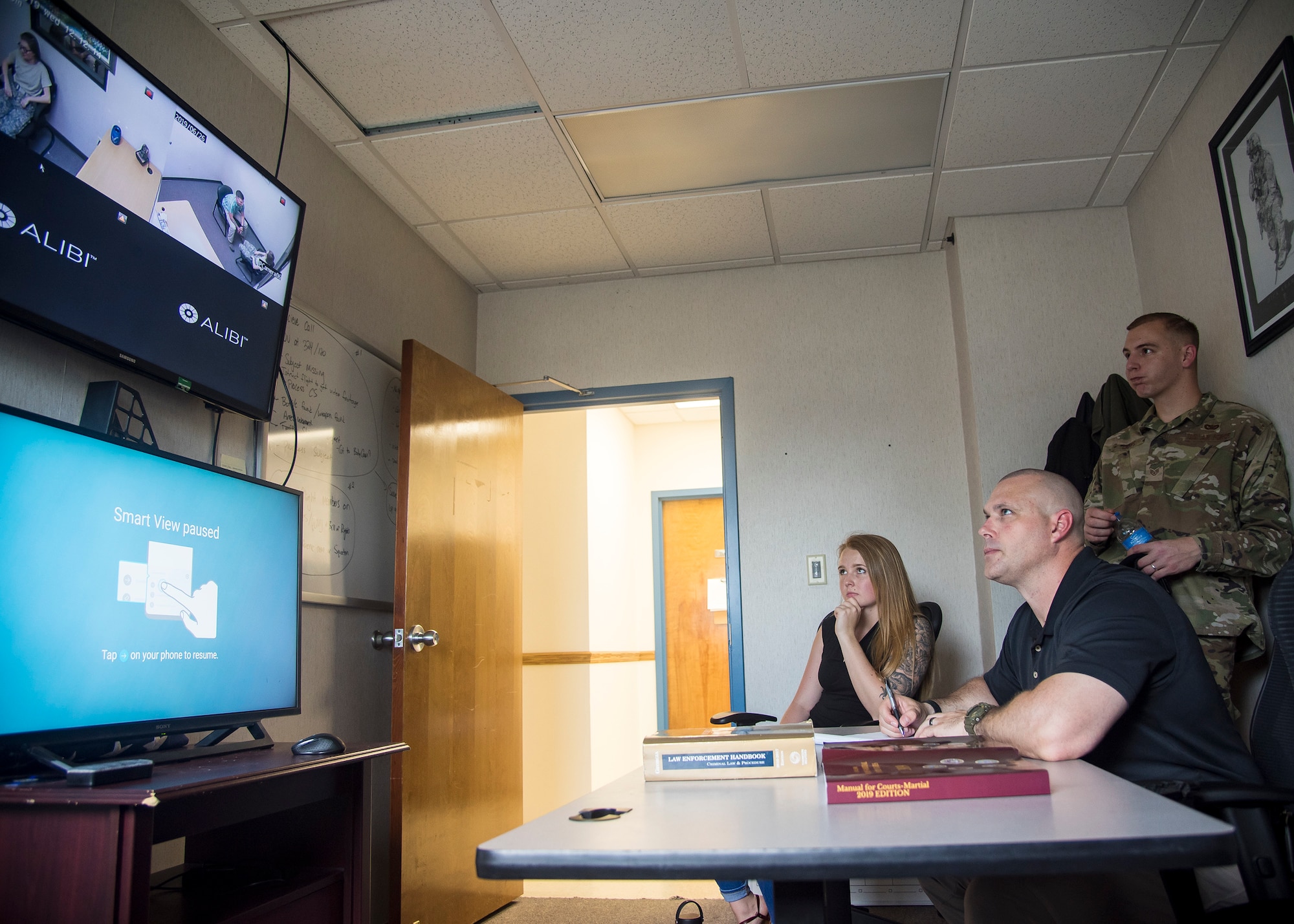 Investigator Joseph Sapikowski, from the 23d Security Forces Squadron, center observes an interrogation during crime scene investigation training, June 26, 2019, at Moody Air Force Base, Ga. After gathering the facts and evidence from a crime scene, investigators will locate and apprehend the suspect and then interrogate them. During interrogation, investigators will question the suspect on the particular incident to get their side of the story to help determine if a crime was committed. (U.S. Air Force photo by Airman 1st Class Eugene Oliver)