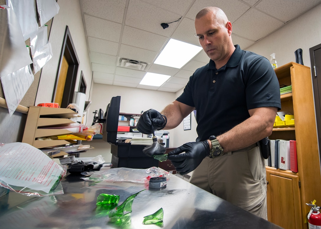 Investigator Joseph Sapikowski from the 23d Security Forces Squadron, brushes fingerprint powder on evidence, June 26, 2019, at Moody Air Force Base, Ga. After arriving at a crime scene, investigators are responsible for the examination, collection and transportation of evidence for further inspection. Once evidence is thoroughly inspected it will be cross-refrenced with the suspects DNA along with the victim’s statements to help determine if they committed a crime. (U.S. Air Force photo by Airman 1st Class Eugene Oliver)