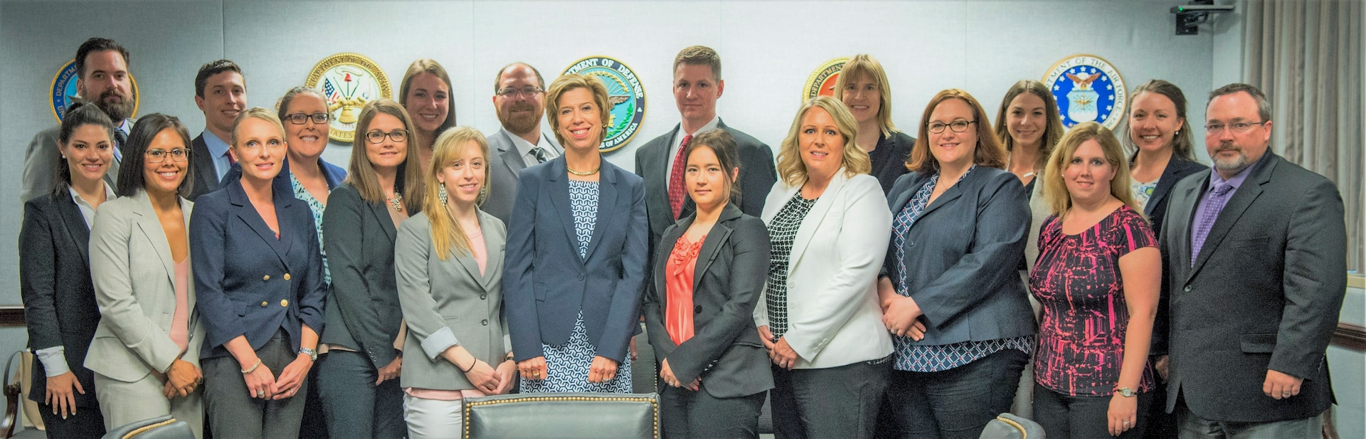 Twenty people in business attire pose for a photo.