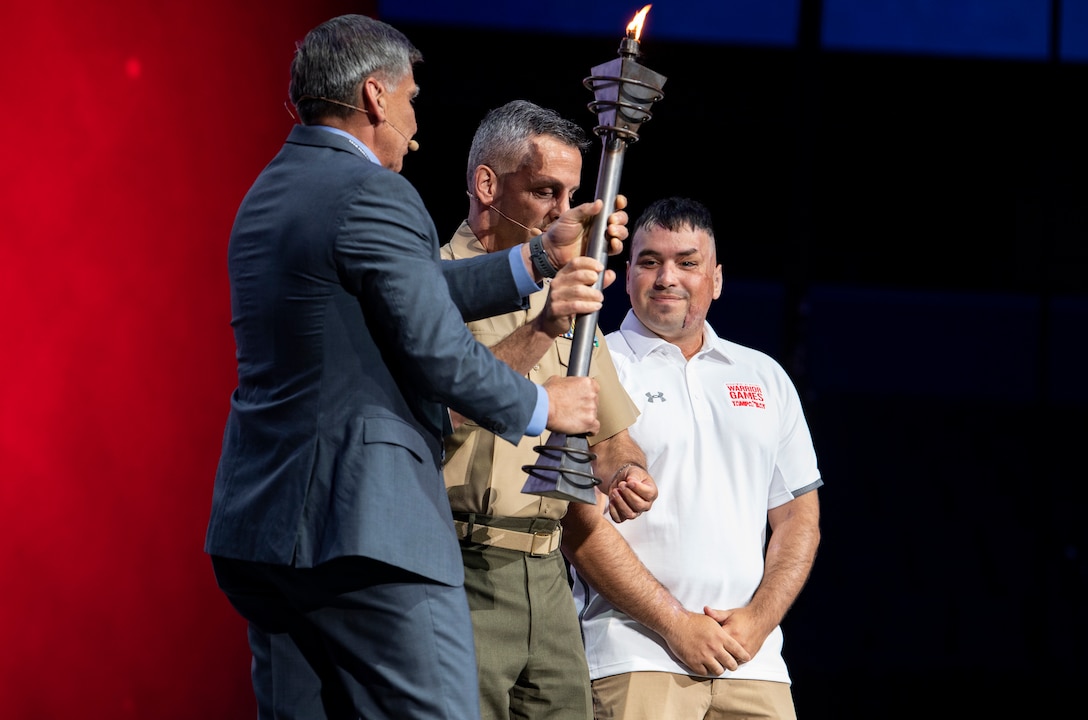 Lt. Gen Michale Rocco, Deputy Commandant for Manpower and Reserve Affairs, and Maj. Gen. Juan Ayala (Ret.), City of San Antonio Director of Military Affairs, receive the torch to signify the transition of DoD Warrior Games host service at Amalie Arena, Tampa, Florida, June 30, 2019. Next year’s games will be hosted by the U.S. Marine Corps in San Antonio, Texas. The 2019 Warrior Games consist of 13 Paralympic-style sports, and more than 300 athletes representing the U.S. Marine Corps, Army, Navy, Air Force, Special Operations Command, and five international teams.