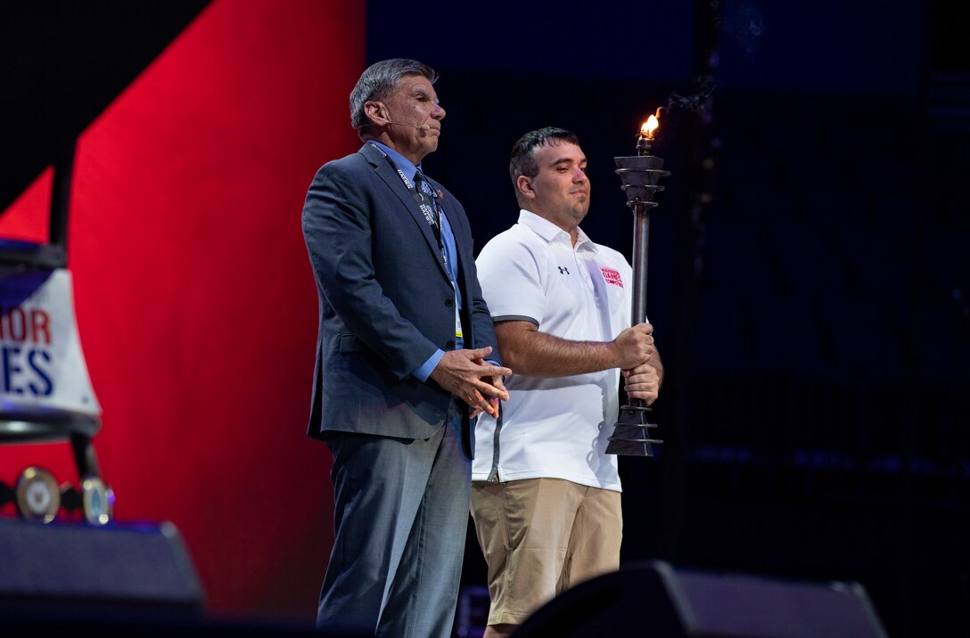 Maj. Gen. Juan Ayala (Ret.), City of San Antonio Director  of Military Affairs  and Cpl. Matthew Maddux, the Ambassador for the 2020 Warrior Games, present the torch on stage after receiving it from U.S. Special Operations Command. Next year’s games will be hosted by the U.S. Marine Corps in San Antonio, Texas. The Warrior Games showcase the resilient spirit of today’s wounded, ill or injured service members from all branches of the military and provide a venue for recovering service members and veterans to demonstrate triumph over significant physical or invisible wounds and injuries.