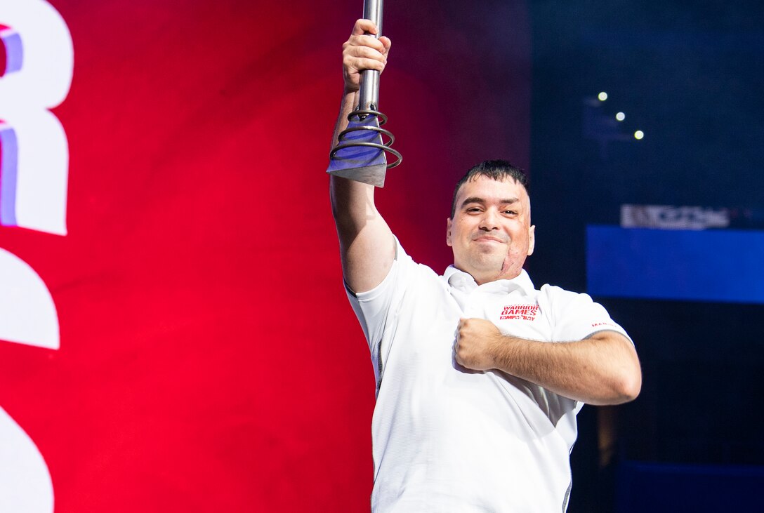 U.S. Marine Corps Cpl. Matthew Maddux holds the DoD Warrior Games ceremonial torch high during the closing ceremony at Amalie Arena, in Tampa, Florida, June 30, 2019. Maddux is the ambassador for next year’s games, which will be hosted by the U.S. Marine Corps in San Antonio, Texas. The Warrior Games showcase the resilient spirit of today’s wounded, ill or injured service members from all branches of the military and provide a venue for recovering service members and veterans to demonstrate triumph over significant physical or invisible wounds and injuries.