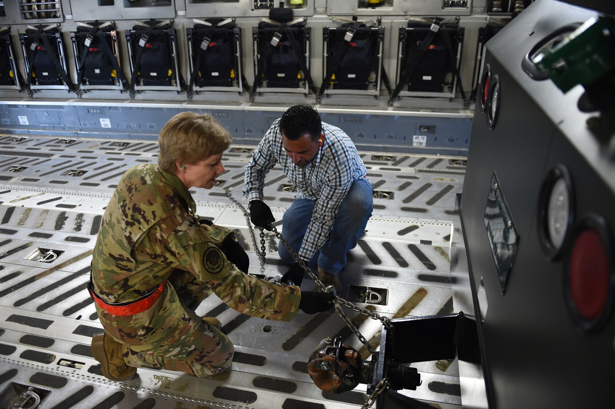 Gen. Maryanne Miller, Air Mobility Command commander, tightens chains on a piece of cargo inside a C-17 Globemaster III alongside Robert Izzeff, 62nd Aerial Port Squadron aerial port expediter load director, June 25, 2019, at Joint Base Lewis-McChord, Wash.