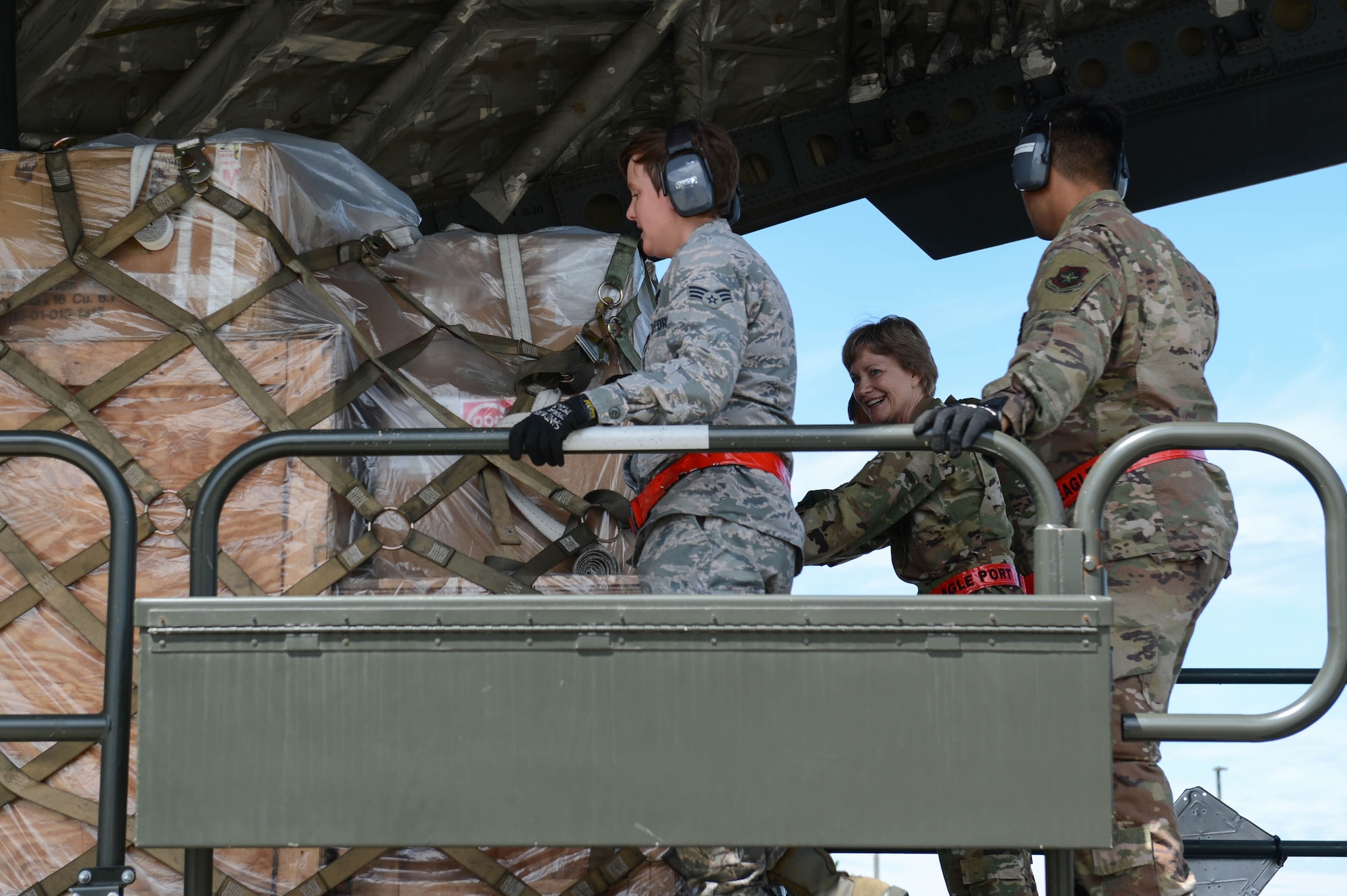 Gen. Maryanne Miller, Air Mobility Command commander, center, and 62nd Aerial Port Squadron Airmen push a pallet of cargo onto a C-17 Globemaster III, June 25, 2019, at Joint Base Lewis-McChord, Wash.