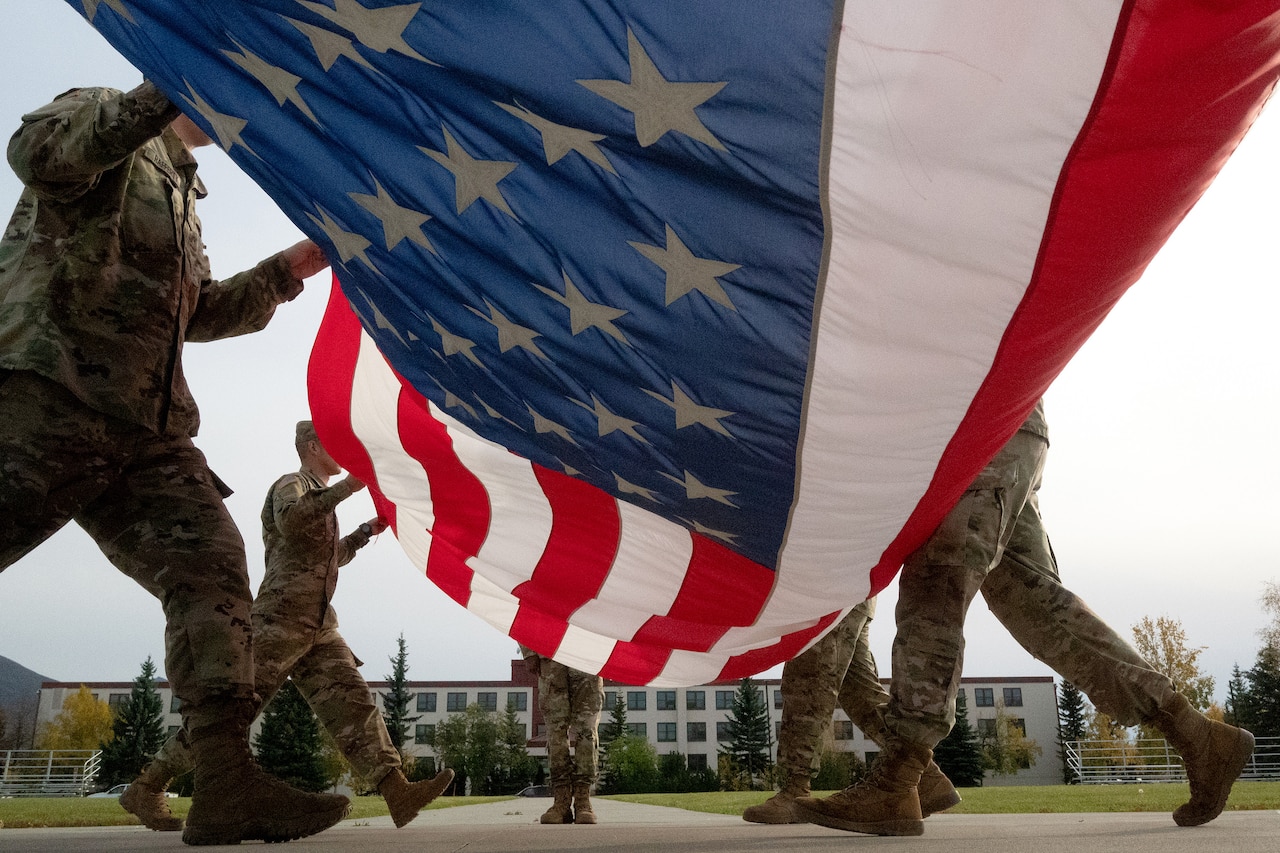 Soldiers fold a flag.