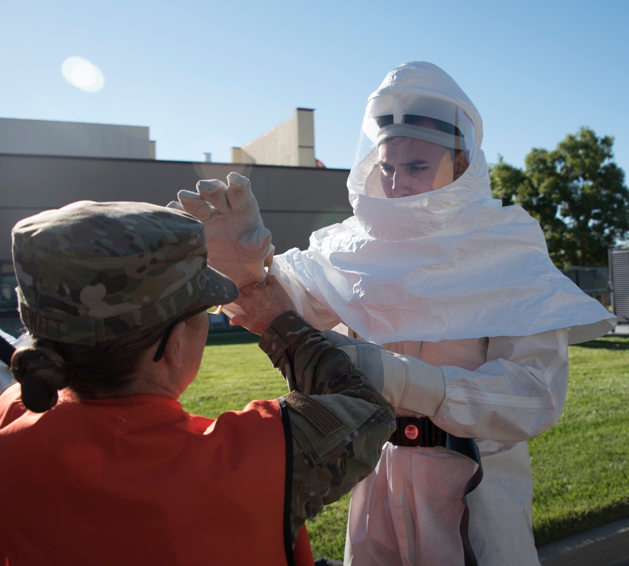 U.S. Air Force Capt. Shannon Hewitt, 60th Medical Operations Squadron, left, assists with a powered air-purifying respirator training suit June 27, 2019, at Travis Air Force Base, California. The suit was part of a hazardous material exercise at David Grant USAF Medical Center. (U.S. Air Force photo by Staff Sgt. Amber Carter)