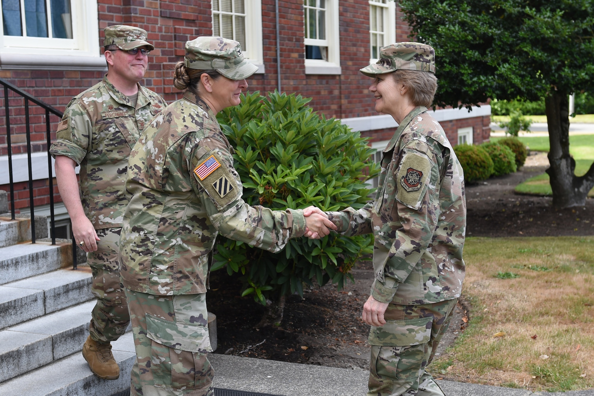 U.S. Army Colonel Nicole Lucas, Joint Base garrison commander, middle, and Col. Bill Percival, 627th Air Base Group and Joint Base deputy commander, far left, greet Gen. Maryanne Miller, Air Mobility Command commander, June 26, 2019 in front of Joint Base Headquarters at Joint Base Lewis-McChord, Wash.