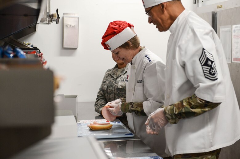 Gen. Maryanne Miller, Air Mobility Command commander, and Chief Master Sgt. Terrence Greene, AMC command chief, make boxed meals at the 627th Force Support Squadron flight kitchen June 26, 2019, at Joint Base Lewis-McChord, Wash.
