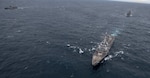 Sailors close up the battle ensign aboard USS Michael Murphy.