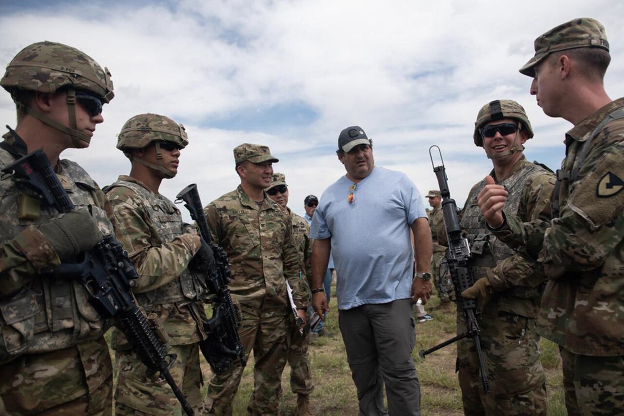 A civilian meets with service members.