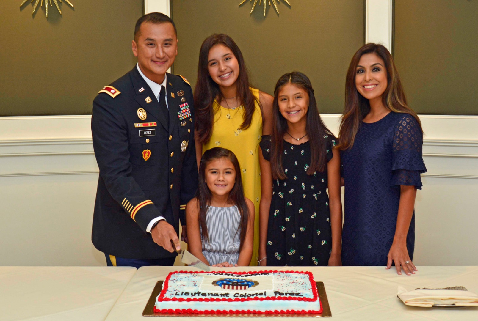Lt. Col. Julian Perez and his family prepare to cut the cake