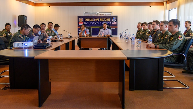 U.S. Air Force Brig. Gen. Ryan Okahara, the Hawaii Air National Guard commander and Indonesia Air Force Air First Marshal Widyargo Ikoputra, the Iswahjudi Air Force Base commander, receives a brief from F-16 Fighting Falcon pilots from both nations prior to the Cope West 19 closing ceremony at Sam Ratulangi International Airport, Manado, Indonesia, June 28. Over the course of the two-week exercise, the two services flew a combined total of 130 sorties, affording both countries the opportunity to exchange knowledge and tactical consideration in modern air combat warfare during close air support training and air-to-air fighter training. Simultaneously, eight subject-matter expert exchanges occurred across various career fields. (U.S. Air Force photo by Staff Sgt. Melanie Hutto)