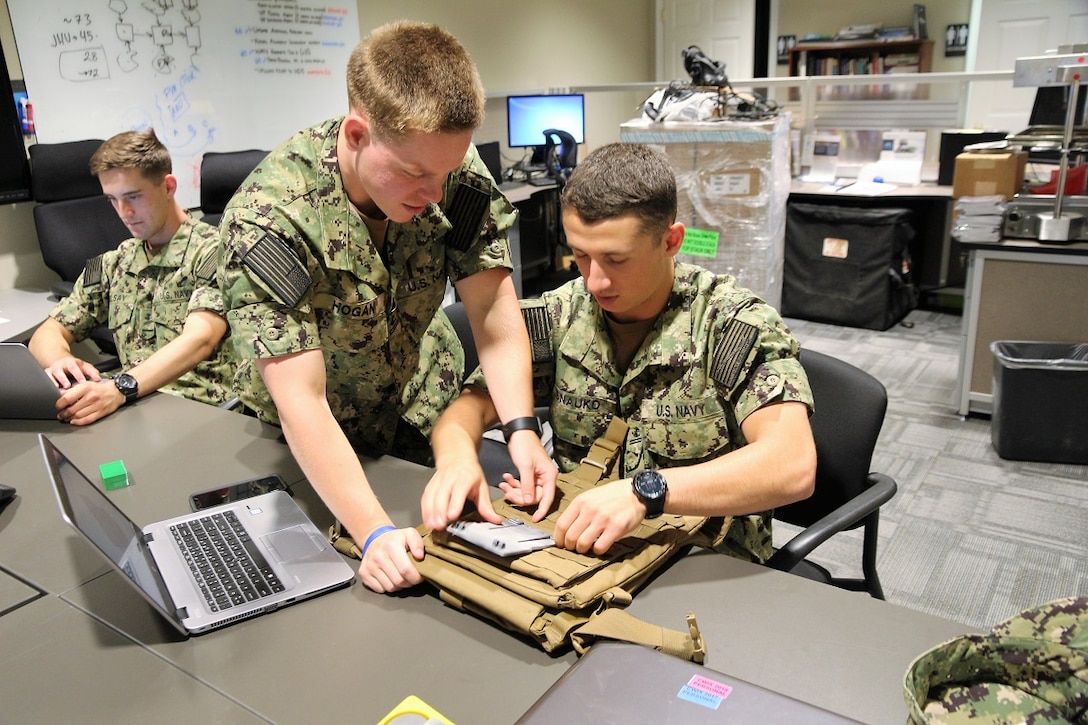 Midshipmen selected for the the Program Executive Officer Land Systems 2019 Internship Program demonstrate work on developing a 3D-printed navigation board prototype for Marines. The program was established in 2013 as a way to introduce cadets and midshipmen from the U.S. Military Academy and USNA to the world of Marine Corps acquisition. (U.S. Marine Corps photo by Ashley Calingo)