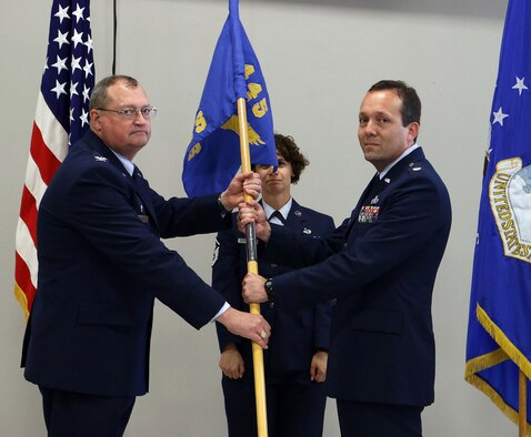 Col. Bryan Runion, 445th Mission Support Group commander, passes the guidon to Lt. Col. Jason Bordas, incoming 445th Civil Engineer Squadron commander, during a change of command ceremony June 1, 2019.