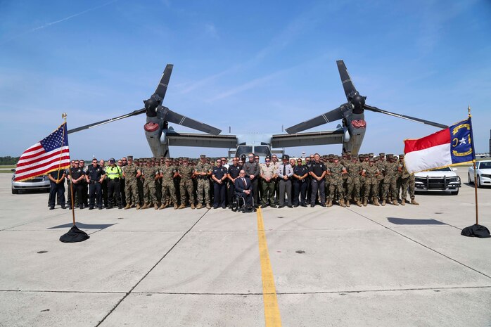U.S. Marines and members of local police forces and members of the Governor’s Highway Safety Program pose for a picture during the 2019 Fourth of July ‘Booze it & Lose it’ event, code-named Operation Firecracker on Marine Corps Air Station New River, July 1, 2019. The event featured speakers from the air station and local law enforcement. The goal of the event was to eliminate preventable loss of life on North Carolina roadways by discouraging driving while impaired and encouraging the public to use other safe options like ride sharing and commercial transportation. This is the first time the event has been held at Marine Corps Air Station New River, which was chosen to be the backdrop due to the large concentration of young male adults who are considered to be the most at-risk age group. (U.S. Marine Corps photo by Sgt. Jonathan Sosner)