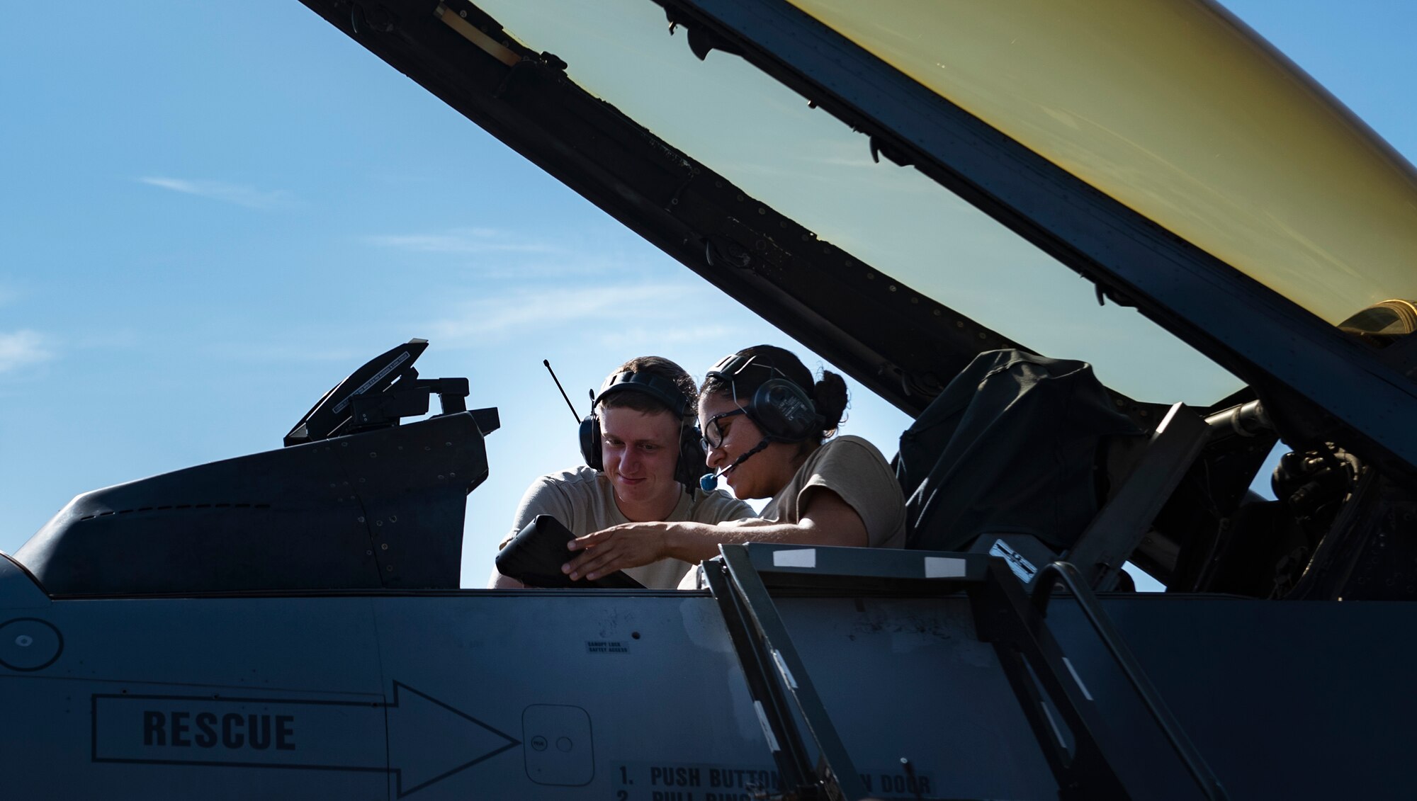 Staff Sgt. Diana Jimenez, right, 362nd Training Squadron F-16 crew chief apprentice course instructor, talks to a student while inside an F-16 Fighting Falcon aircraft at Sheppard Air Force Base, Texas, July 2, 2019. Jimenez is showing the student the lights operations check checklist and shows him which ones are done in the flightdeck. (U.S. Air Force photo by Airman 1st Class Pedro Tenorio)