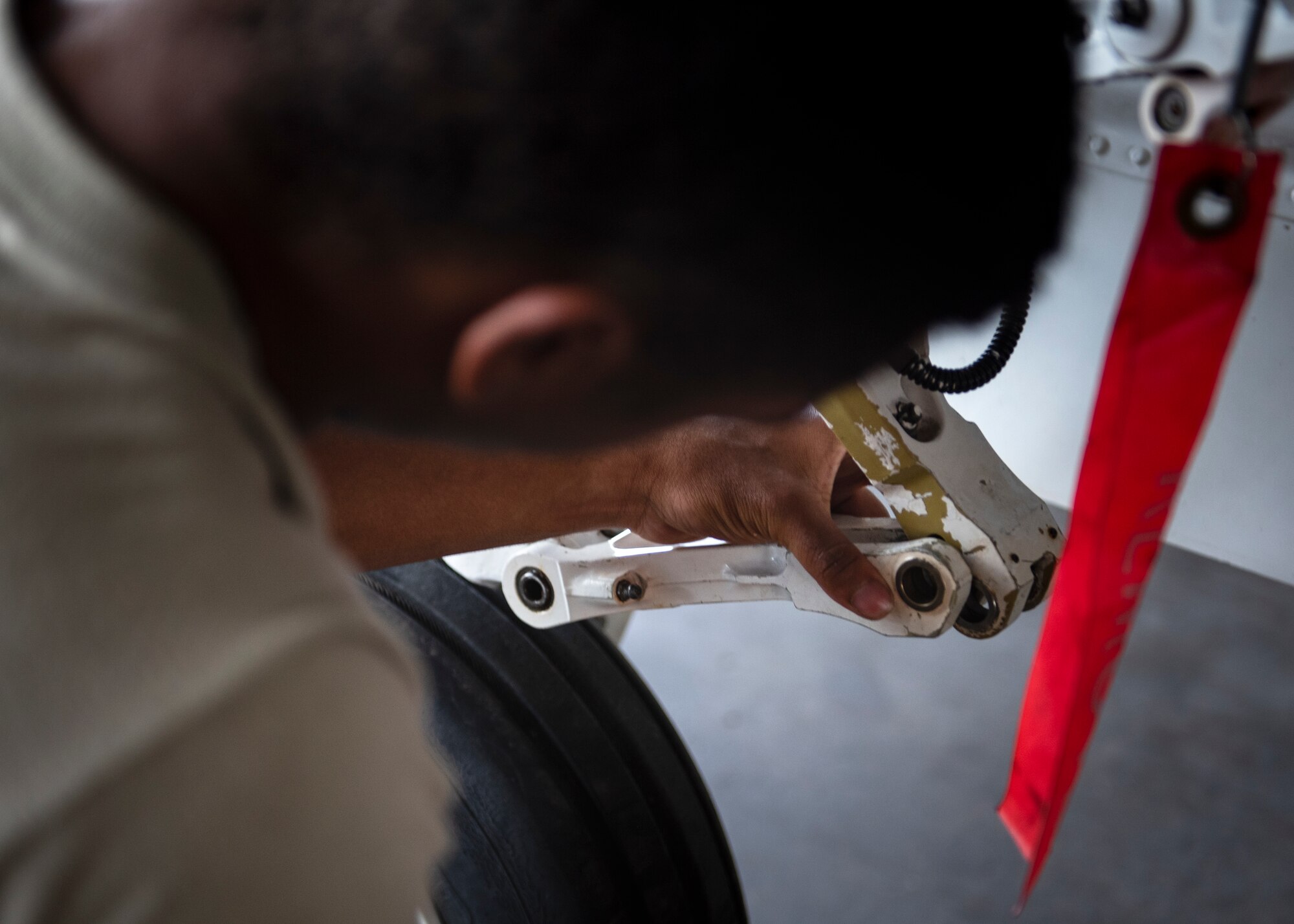 Airman Anthony Washington, 362nd Training Squadron F-16 crew chief apprentice course student, connects the torque links on the front landing gear at Sheppard Air Force Base, Texas, July 2, 2019. Torque links when disconnected allows the wheel to move around more freely, they are connected before flight though as a free wheel moving in multiple directions would not be the best for landing. (U.S. Air Force photo by Airman 1st Class Pedro Tenorio)
