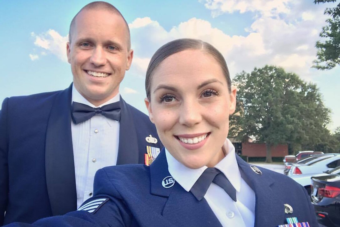 Two airmen pose for a selfie photo in uniform.