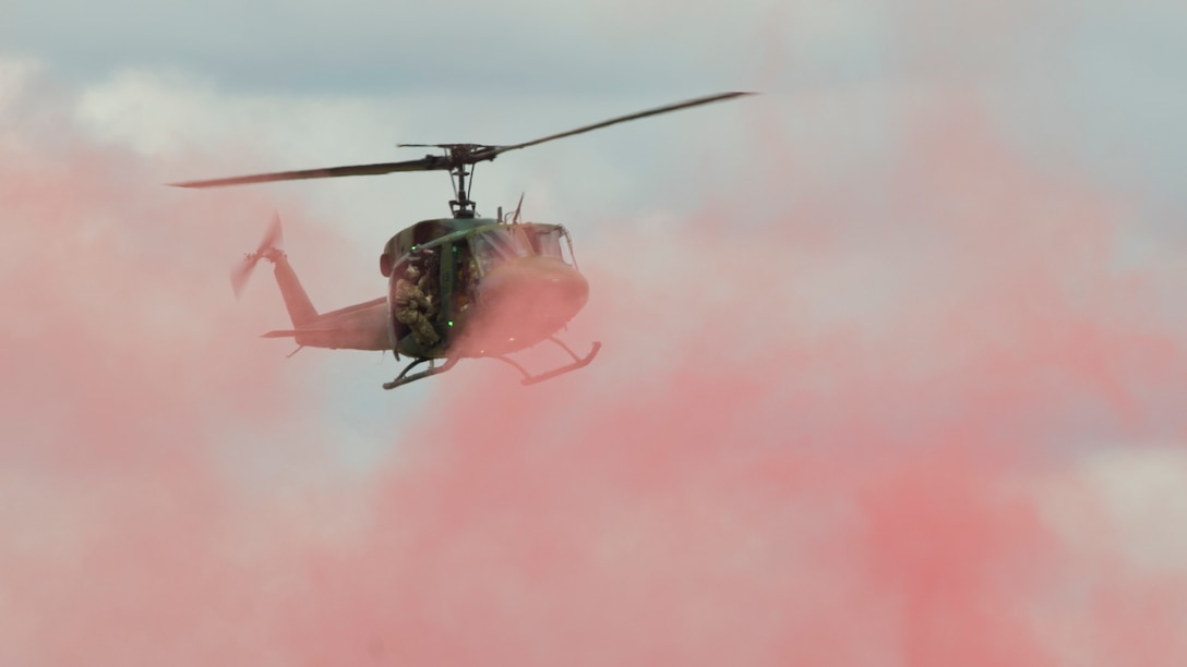 A UH-1 Iroquois helicopter from the 36th Rescue Squadron hovers over a marker-flare to perform a rescue demonstration at the 2019 Skyfest Open House and Air Show at Fairchild Air Force Base, Washington, June 22, 2019. Fairchild opened its gates to the public for a free one-day event to showcase Pacific Northwest airpower and U.S. Air Force capabilities. The airshow included the F-22 Demonstration Team, U.S. Army Golden Knights and 11 other aerial acts. (U.S. Air Force photo by Senior Airman Ryan Lackey)