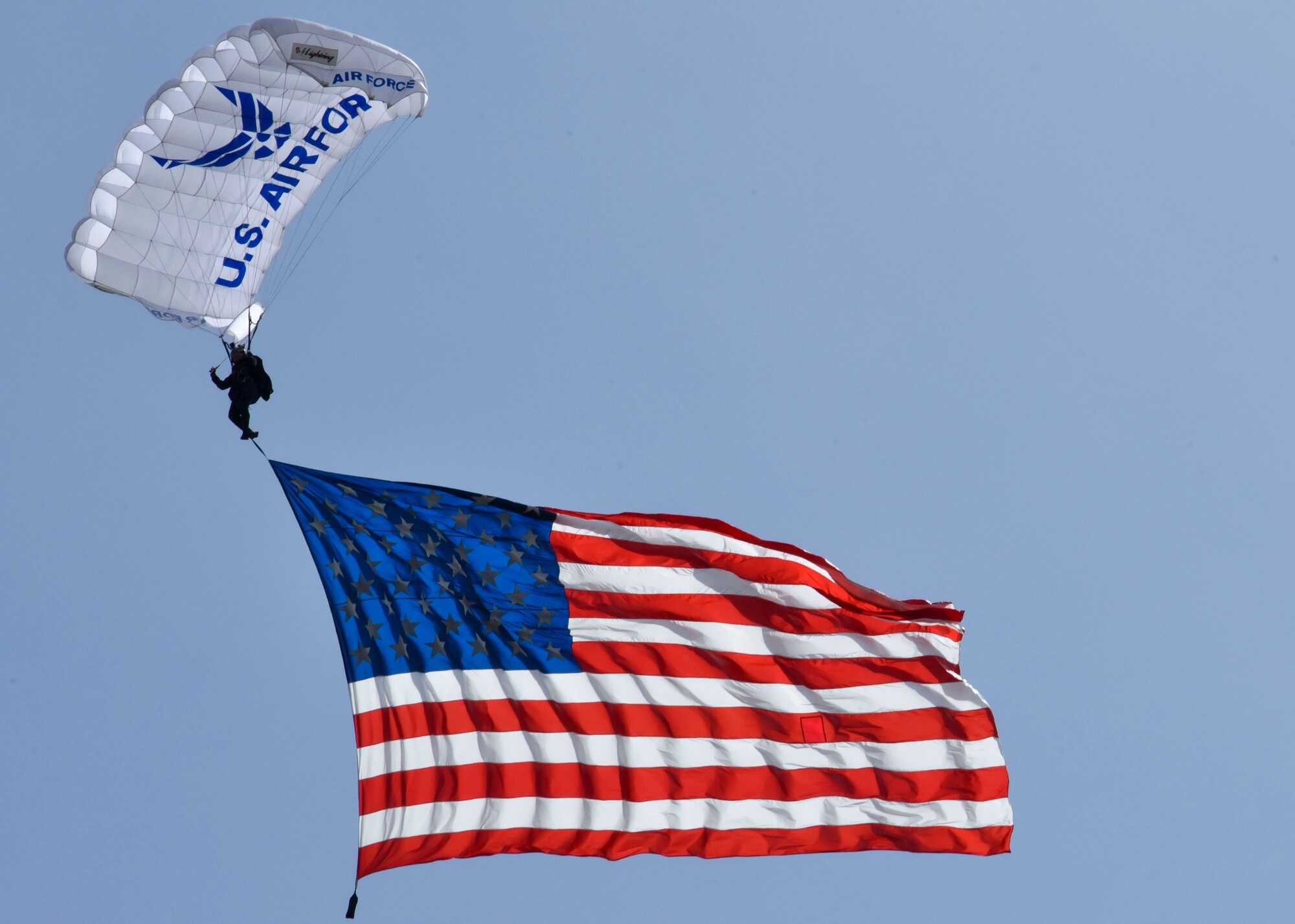 U.S. Air Force Cadet Sara Hill, Air Force Academy Wings of Blue team member, jumps from a C-130 Hercules while carrying the American flag during the 2019 Skyfest Open House and Airshow  on Fairchild Air Force Base, Washington, June 22, 2019. Skyfest 2019 offered a unique view of Team Fairchild’s role in enabling Rapid Global Mobility for the U.S. Air Force. The show featured more than 13 aerial acts and 16 static display aircraft, as well as other attractions and displays. (U.S. Air Force photo by Airman Kiaundra Miller)