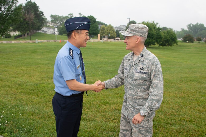 Col. Kyun Do Ki, left, Republic of Korea Air Force Weather Wing commander, and Col. Brian Pukall, right, 557th Weather Wing commander, shake hands in front of the 557th WW’s headquarters building at Offutt Air Force Base, Nebraska, June 20, 2019. The visit included mission briefs, a tour of the wing headquarters and discussions of topics including data sharing and future cooperation. (U.S. Air Force photo by Paul Shirk)