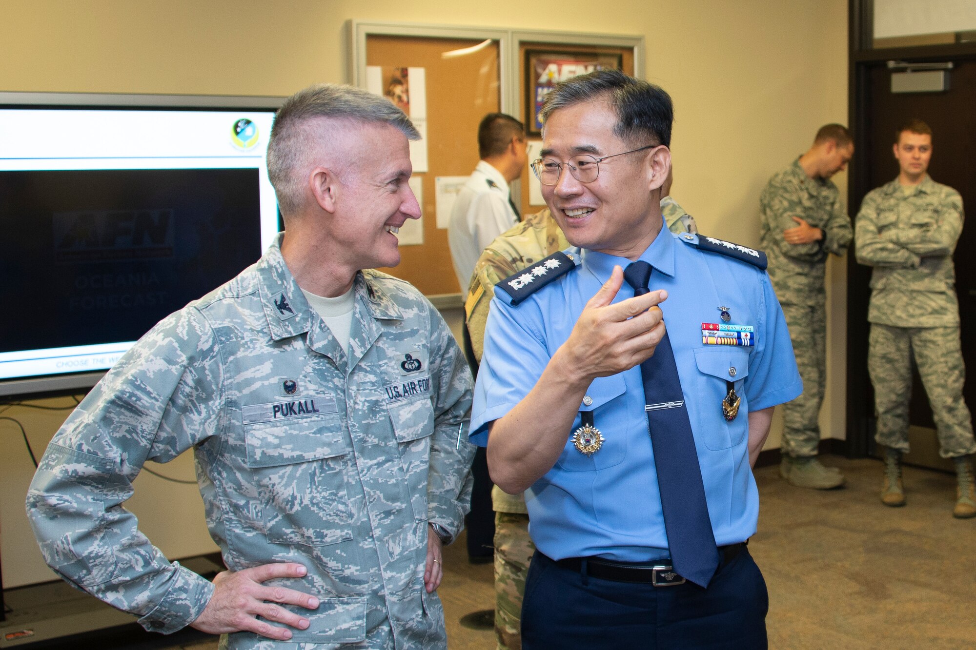 Col. Brian Pukall, left, 557th Weather Wing commander, and Col. Kyun Do Ki, right, Republic of Korea Air Force Weather Wing commander, talk during a demonstration at the American Forces Network Weather Center at the 557th WW headquarters building, Offutt Air Force Base, Nebraska, June 20, 2019. The AFN Weather Center records daily weather forecasts for the AFN audience as well as Stars and Stripes readers around the world. (U.S. Air Force photo by Paul Shirk)
