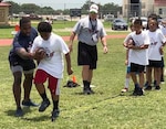Houston Texans running back Lamar Miller (left) hosted a football camp for about 150 Joint Base San Antonio-Randolph Air Force Base youth from the first through eighth grades July 1-2. Miller, who has been with the Texans for three seasons, led the football camp to help military children to learn the game of football and live healthier lifestyles.
