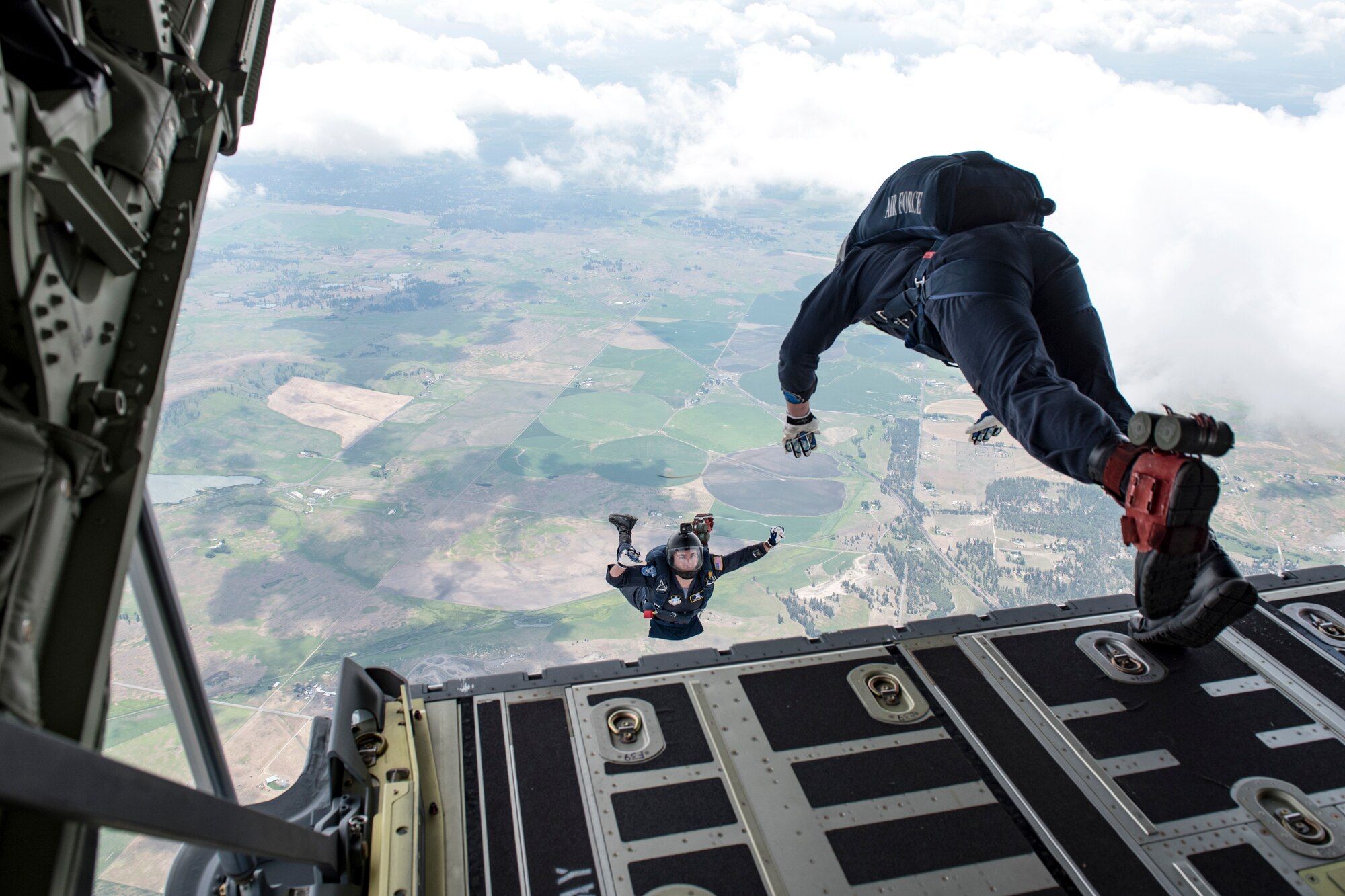U.S. Air Force Academy Wings of Blue team members Steve Rumsey and Trevor Pratt, , leap off of the C-130 Hercules ramp from 7,700 feet to the ground bellow during the 2019 Skyfest Open House and Airshow performance at Fairchild Air Force Base, Washington, June 22, 2019. Skyfest 2019 offered a unique view of Team Fairchild’s role in enabling Rapid Global Mobility for the U.S. Air Force. The show featured more than 13 aerial acts and 16 static display aircraft, as well as other attractions and displays. (U.S. Air Force photo by Airman 1st Class Whitney Laine)