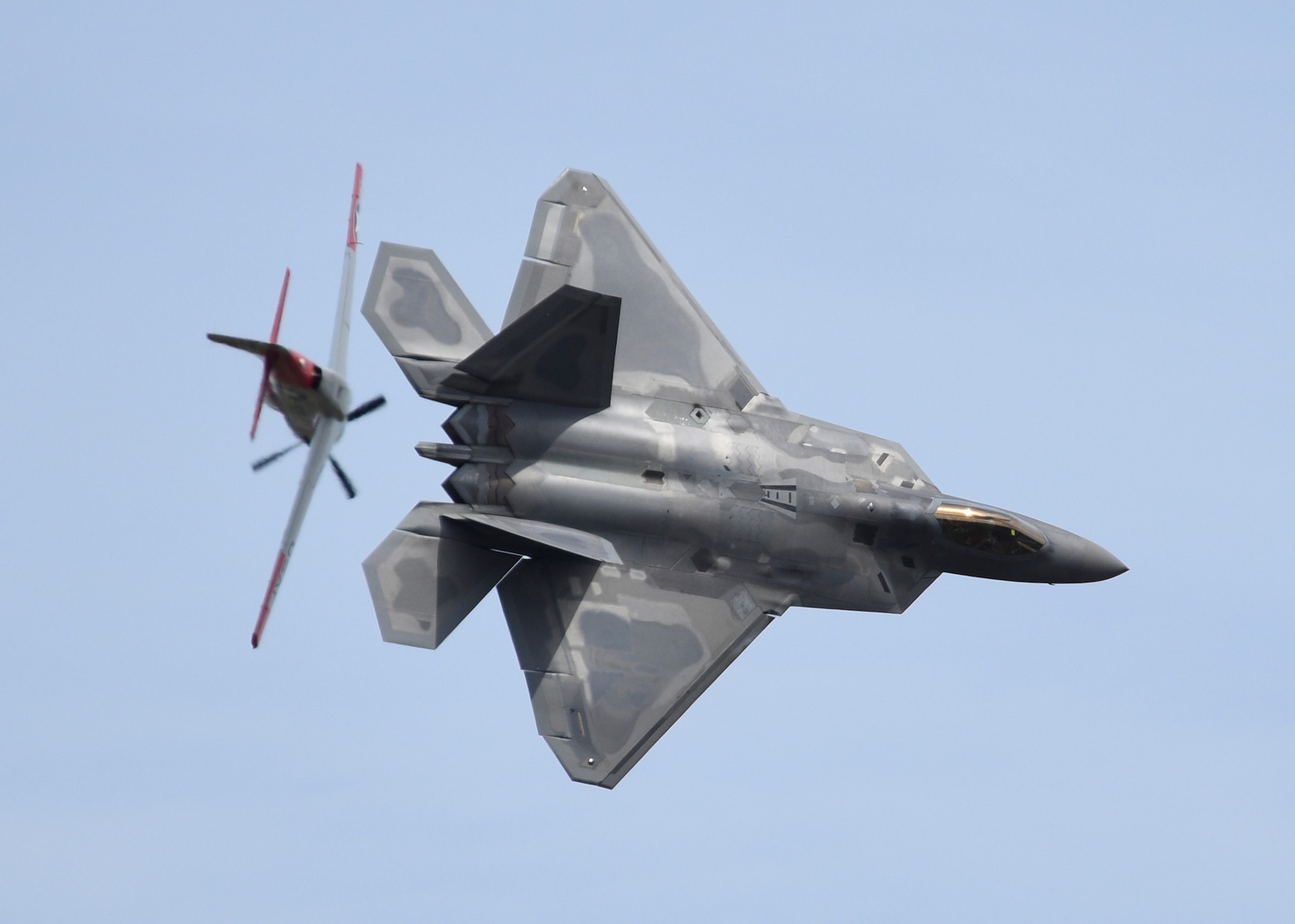 An F-22 Raptor and a P-51 Mustang perform a Heritage Flight during the 2019 Skyfest 2019 Open House and Air Show at Fairchild Air Force Base, Washinton, June 22, 2019. Skyfest 2019 Open House and Airshow offered a unique view of Team Fairchild’s role in enabling Rapid Global Mobility for the U.S. Air Force. The show featured more than 13 aerial acts and 16 static display aircraft, as well as other attractions and displays. (U.S. Air Force photo by Airman 1st Class Lawrence Sena)