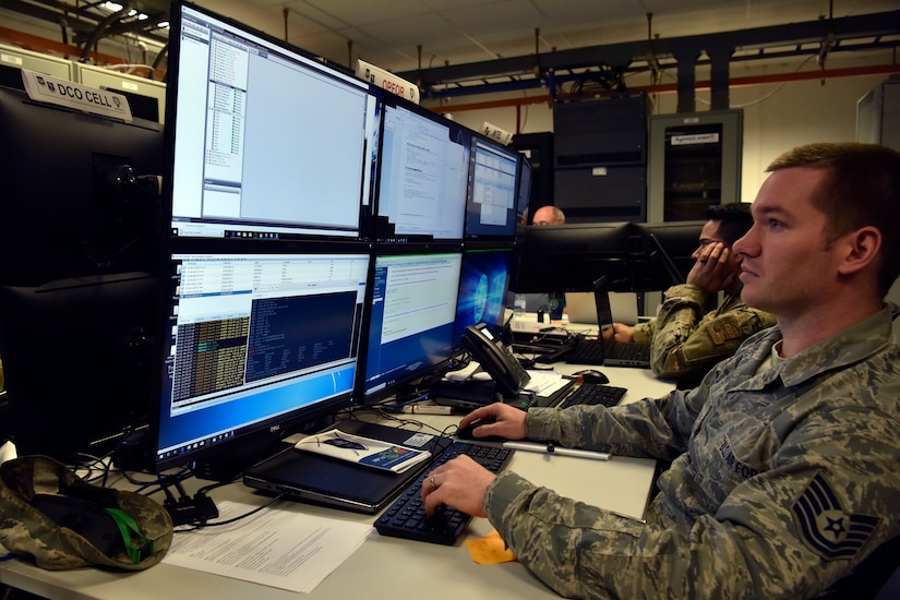 Service members work at a computer.