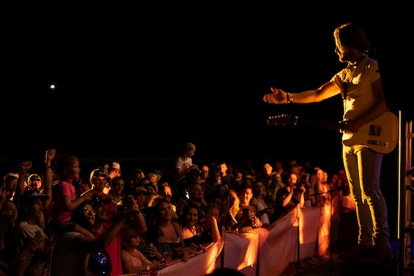 Chase Bryant, country music artist, right, blows a kiss to a Team Shaw child during the 20th Force Support Squadron Freedom Bash concert at Shaw Air Force Base, South Carolina, June 29, 2019.