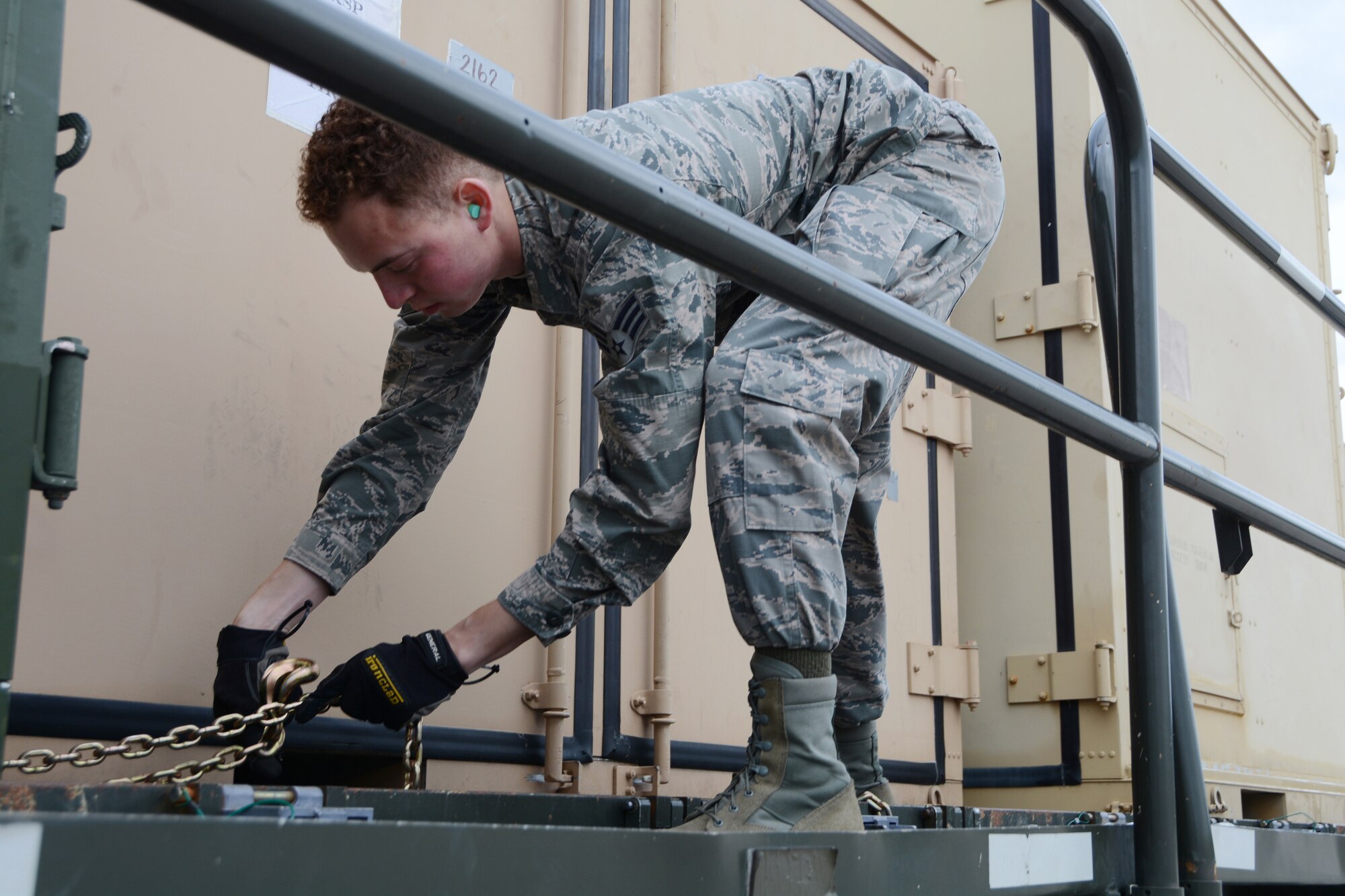Senior Airman Timothy Watson, 26th Aerial Port Squadron air transportation specialist, chains a cargo container onto a K-loader, June 10, 2019, in preparation for exercise Swift Response 19, at Ramstein Air Base, Germany.