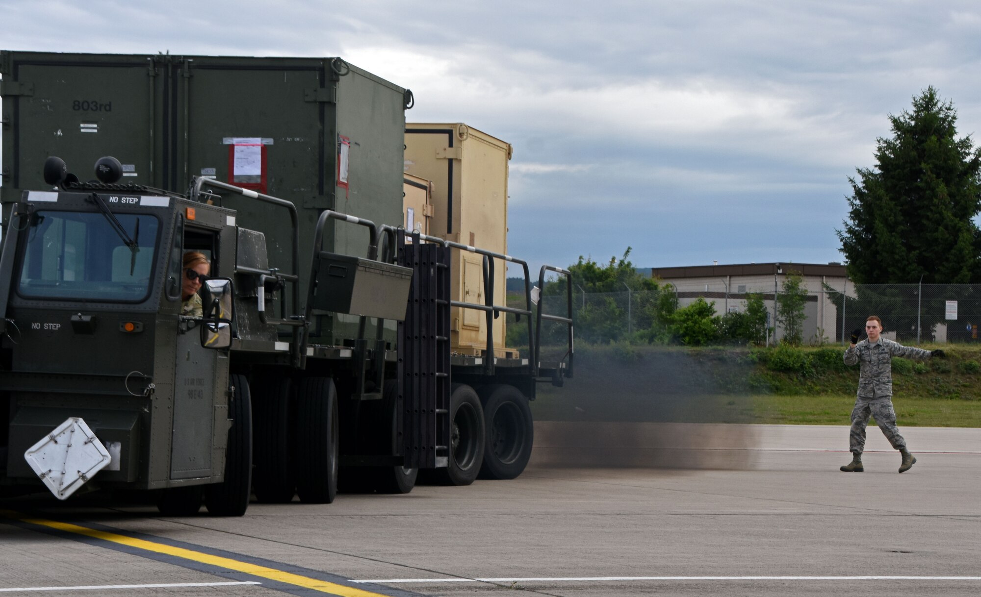 Senior Airman Timothy Watson, 26th Aerial Port Squadron air transportation specialist, guides Staff Sgt. Michelle Grazier, 26th APS air transportation specialist, as she backs-up a K-loader, June 10, 2019, in preparation for exercise Swift Response 19, at Ramstein Air Base, Germany.
