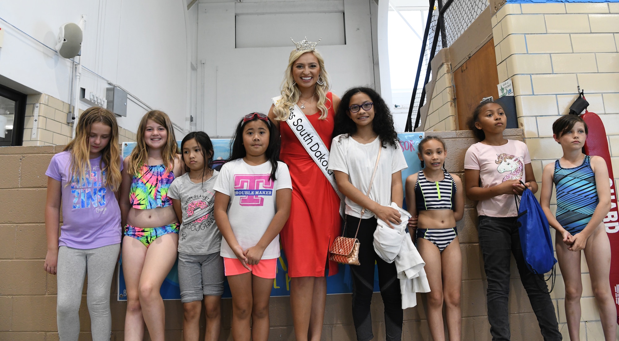 Amber Hulse, Miss South Dakota takes a photo with children at the Summer Splash event at Ellsworth Air Force Base, S.D., July 1, 2019. Hulse came out to meet children on base, sign autographs and take photos with participants. (U.S. Air Force photo by Senior Airman Thomas Karol)